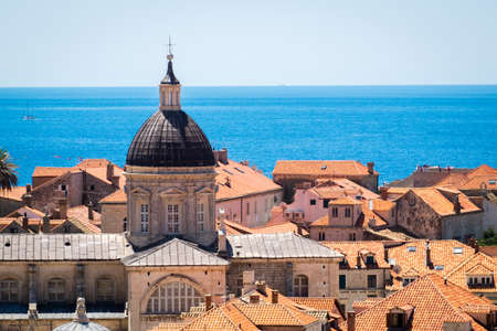 Old Town houses with red tiled roofs and rocky green idyllic island in background, Dubrovnik, Dalmatia, Croatiaのeditorial素材