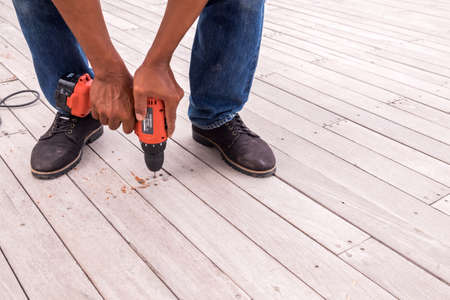 Drilling machine working on wooden floorの写真素材