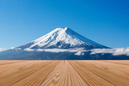 Empty wooden desk space with fuji mountains backgroundの写真素材