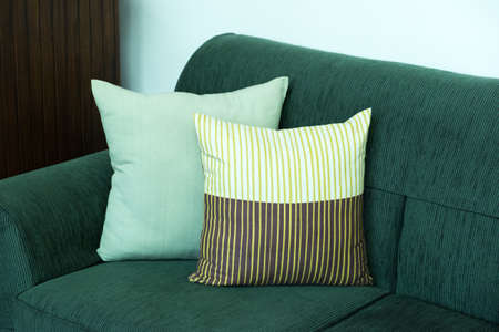 Sofa with green pillows in room