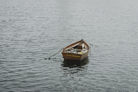 Old fishing boat on the waves of the blue seaの写真素材
