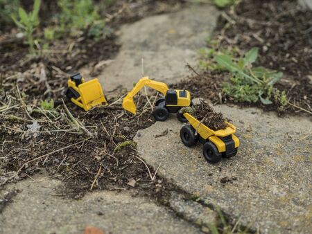 Toy construction machinery working on an excavation