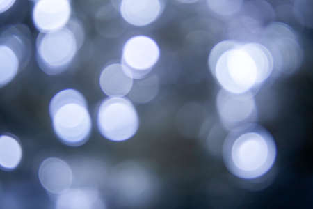 Blurred lights dark gray blue background. Abstract bokeh with soft light. Shiny festive christmas textureの写真素材