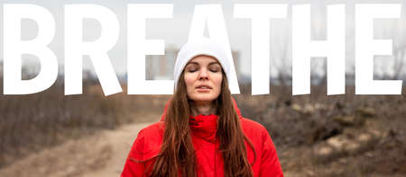 Beautiful young woman with long hair inhales fresh air with her eyes closed with big white word...