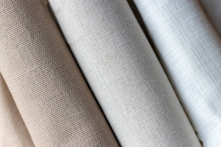 Diagonal textural background of three types of natural linen fabric, rolled up. Selective focus. Closeup viewの写真素材