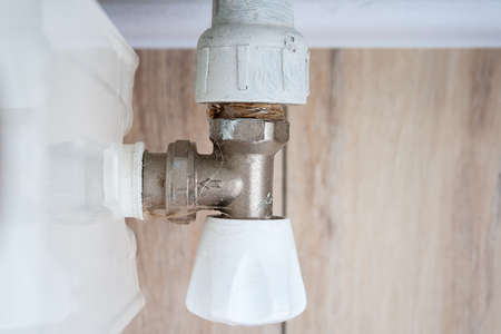 Closeup top view of a heat control valve located on the side of a home heating radiator in a living room. Temperature regulator. Thermostatic knobの写真素材