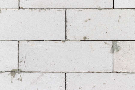 Smooth white brick wall with traces of cement background textureの写真素材