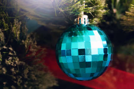 A blue ball hanging on an artificial Christmas treeの写真素材