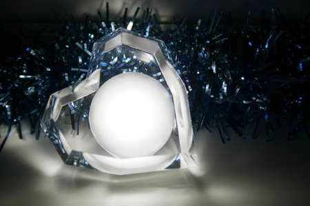 A glowing heart lying against the background of a blue garlandの写真素材