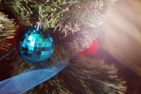 A blue ball hanging on an artificial Christmas treeの写真素材