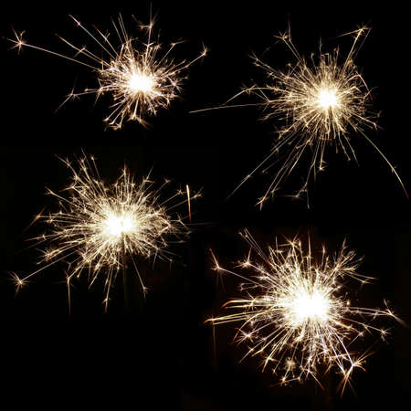 Set of four bright burning sparklers on a black backgroundの写真素材