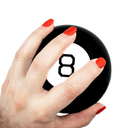 Magic 8 ball of predictions in female hand with red nails isolated on white backgroundの写真素材