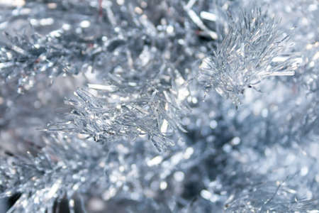Silver artificial Christmas tree branches background. Selective focus. Closeup view. New Year's Eve home decorationの写真素材