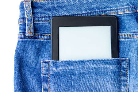 A modern black electronic book with a blank screen in the back pocket of bright blue jeans. Mockup tabletの写真素材
