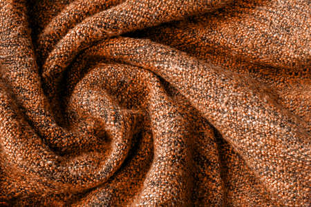 Bright orange knitted fabric texture. Crumpled twisted blanket background. Selective focus. Closeup viewの写真素材