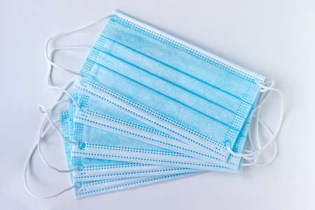 Blue protective medical face masks on a white background. Respiratory protection during quarantine, virus, coronavirus, air pollutionの写真素材