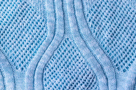 Bright blue knitted fabric texture. Rough sweater pattern background. Closeup viewの写真素材