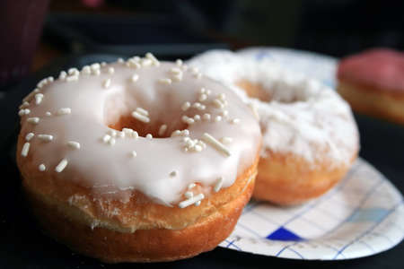 Sweet lush donuts in white sugar glaze closeup. Selective focusの写真素材