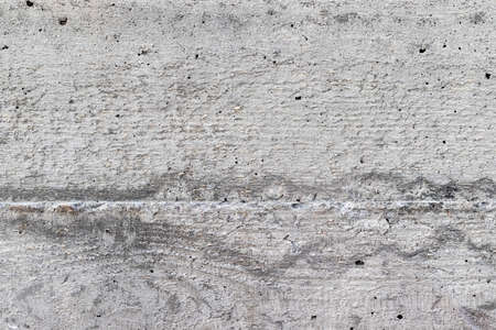 Gray, rough, concrete background texture. Wall with holes and various splashesの写真素材
