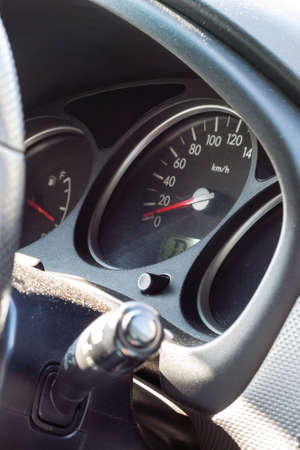 Car dashboard with speedometer and fuel level gauge. Closeup side view on a sunny dayの写真素材