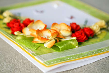 Closeup view of a scrapbooking card with paper flowers, ribbons and hand stitchingの写真素材