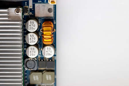 Part of a computer motherboard with capacitors, a transformer and a cooling radiator. Selective...