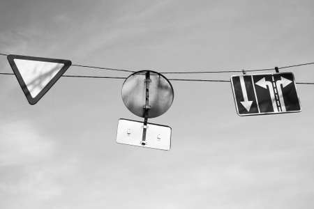 Three road signs hang on wires. Black and white photoの写真素材