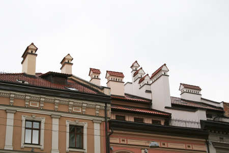 Chimneys in the form of small houses, located on the tiled roof of the houseの写真素材