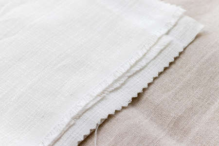 Textural background of two types of natural linen fabric lying on top of each other. Selective focus. Closeup viewの写真素材