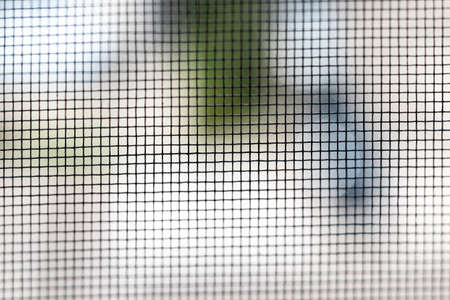 Mosquito net on the window closeup. Protection of the house from small insects. Background. Selective focusの写真素材