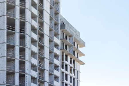 High-rise building under construction against a light blue skyの写真素材