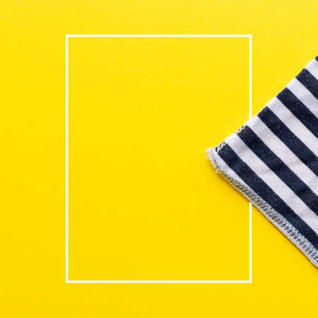 Blue and white striped fabric triangle on a bright yellow background with a white rectangular frame...