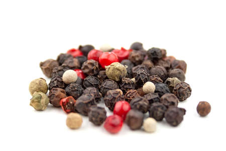 A mix of four types of pepper grain: black, white, pink, green. Isolated on white background....