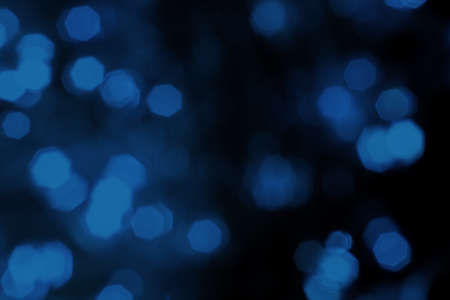 Blurred lights dark blue background. Abstract bokeh with soft light. Shiny festive christmas textureの写真素材