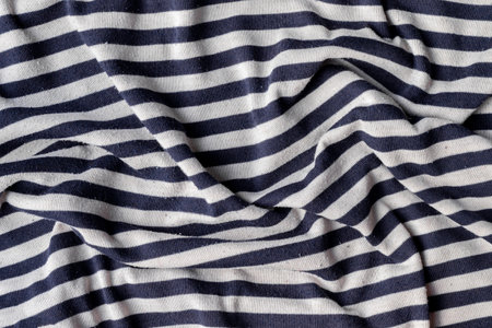 Cotton jersey striped fabric with pills texture. Crumpled blue and white textile background