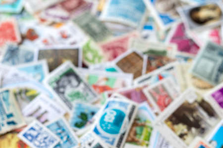 Blurred defocused background texture from old multicolored postage stamps collection from different countriesの写真素材