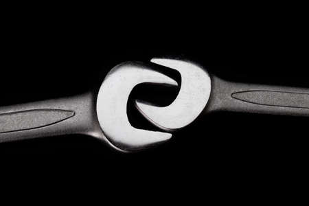 Two steel wrenches isolated on black background closeup. Concept of love, relationship, valentines...