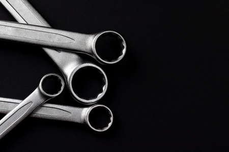 Four steel closed end ring wrenches isolated on black background closeup with copy spaceの写真素材