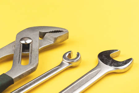 Work tools on bright yellow background closeup