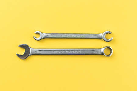 Wrenches on bright yellow background, steel hand work tools