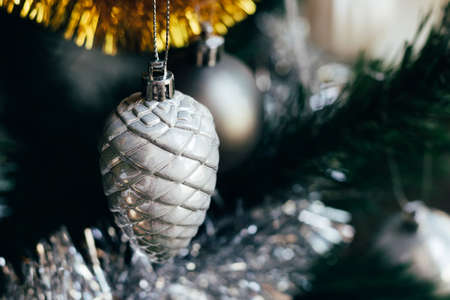Silver gray toy cone on decorated Christmas tree. Holiday card with decorations for the New Years Eve. Selective focusの写真素材
