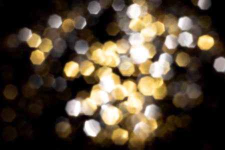 Golden and silver blurred bokeh lights on black background. Glitter sparkle stars for celebrate. Overlay for your designの写真素材