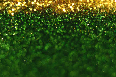 Green and gold sparkling glitter bokeh background, christmas abstract defocused texture. Holiday...