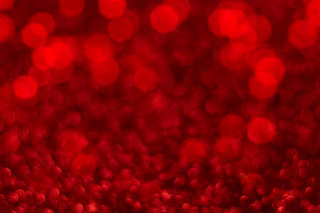 Red sparkling glitter bokeh background, christmas abstract defocused texture. Holiday lightsの写真素材