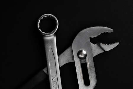 Steel closed end ring wrench and pliers on black background with copy spaceの写真素材