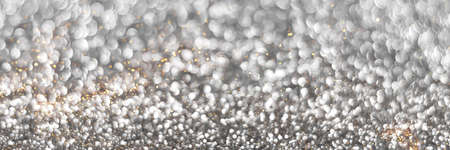 Silver and golden sparkling glitter bokeh background, christmas texture. Holiday lights. Abstract defocused header. Wide screen wallpaper. Panoramic web banner with copy space for designの写真素材