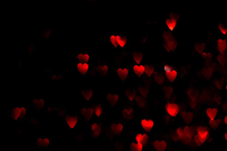 Red hearts, blurred bokeh lights on black background. Glitter sparkle for valentines day. Overlay for your designの写真素材