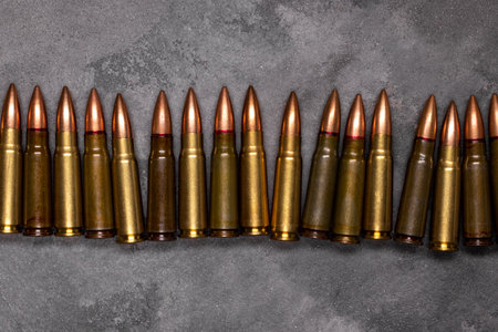 Bullets on gray background. Cartridges 7.62 caliber for assault rifle. Top view, flat lay