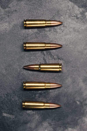 Bullets on gray background. One bullet positioned in opposite direction from others. Cartridges 7.62...