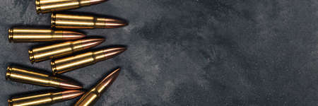 Bullets on gray background banner with copy space. Cartridges 7.62 caliber for Kalashnikov assault rifle. Panoramic web header. Wide screen wallpaperの写真素材